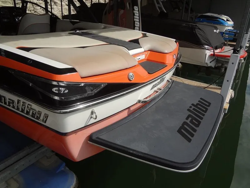 Slide: The Image of 2010 Malibu VLX Wakesetter boat with swim platform, docked in marina. - 6