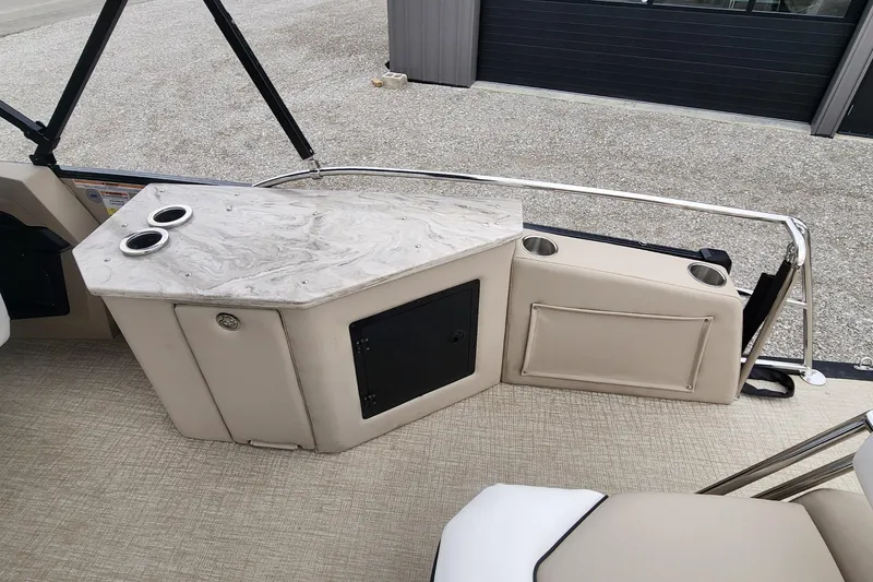 Slide: The Image of 2025 Avalon Platinum Catalina 2585 Cruise Rear Bench interior with cup holders and storage. - 10