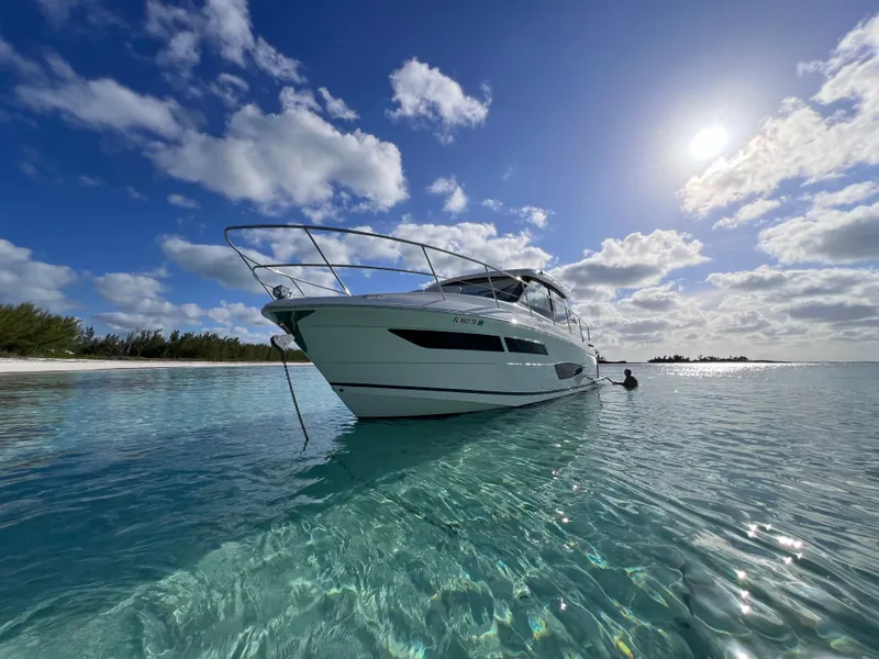 Slide: The Image of 2022 Regal 38 XO yacht anchored in clear turquoise waters under a sunny sky. - 2