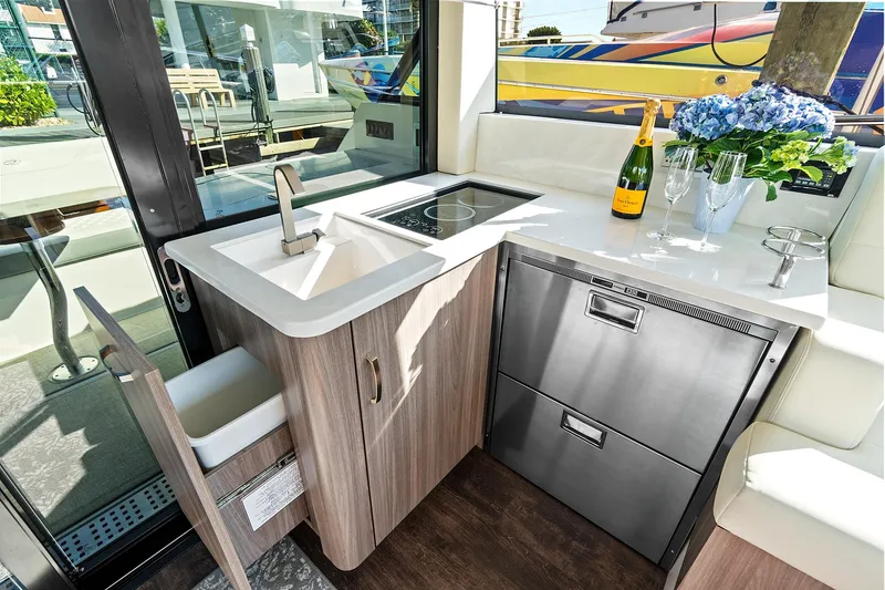 Slide: The Image of Modern kitchen area in 2022 Regal 38 XO yacht with sink, stove, and stainless steel appliances. - 23