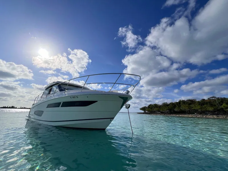 Slide: The Image of 2022 Regal 38 XO yacht anchored in clear blue water under a sunny sky. - 3