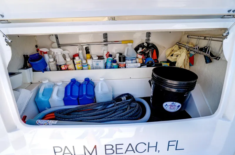 Slide: The Image of Storage compartment of 2022 Regal 38 XO boat with cleaning supplies, hoses, and equipment. - 48