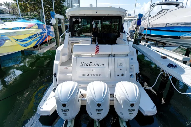 Slide: The Image of 2022 Regal 38 XO boat docked, featuring triple outboard engines and "SeaDancer" nameplate. - 5