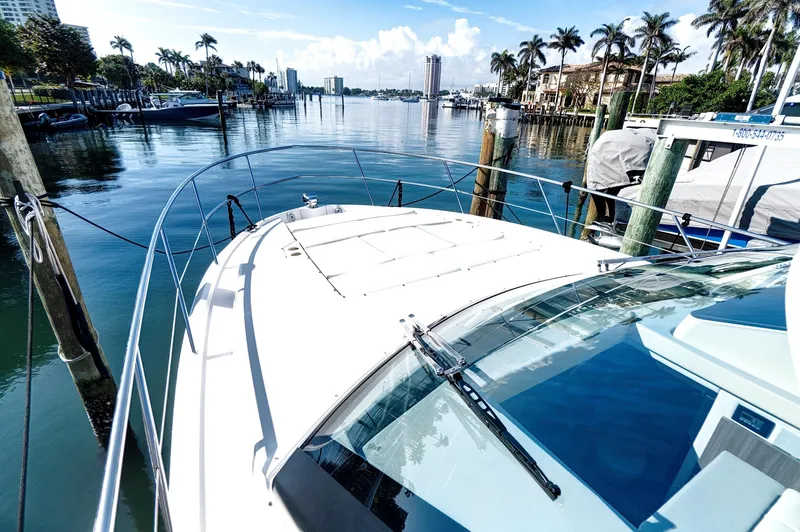 Slide: The Image of 2022 Regal 38 XO yacht docked in a scenic marina with palm trees. - 8