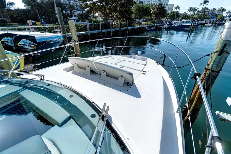 Slide: The Image of 2022 Regal 38 XO yacht docked in a marina, featuring a spacious sun deck. - 9