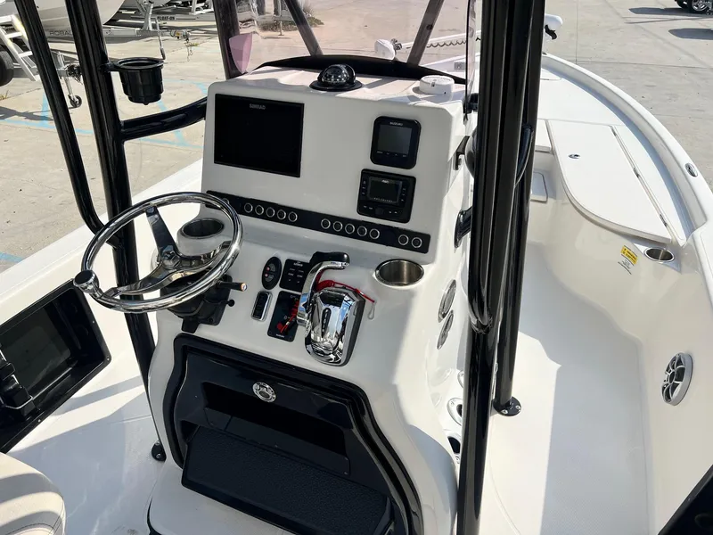 Slide: The Image of 2021 Blue Wave 2400 PURE BAY boat console with steering wheel and navigation controls. - 4