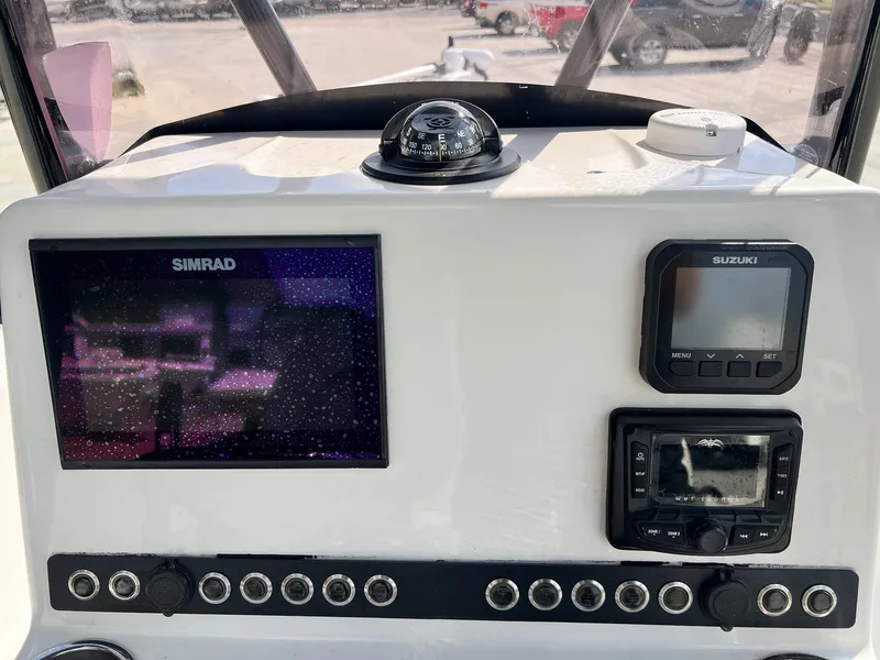 Slide: The Image of Boat dashboard with Simrad display, Suzuki control, and compass on Blue Wave 2400 PURE BAY. - 5