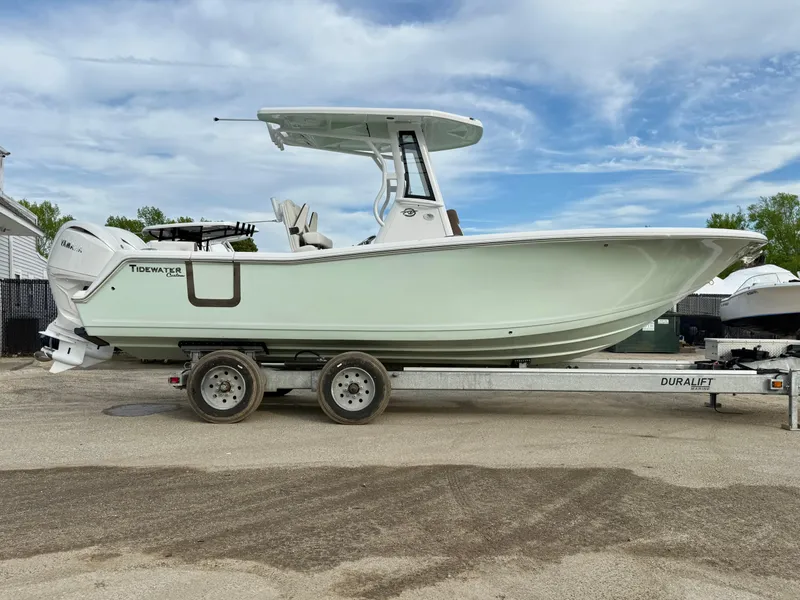 Slide: The Image of 2025 Tidewater 256 LXF boat on trailer, side view, under a cloudy sky. - 10