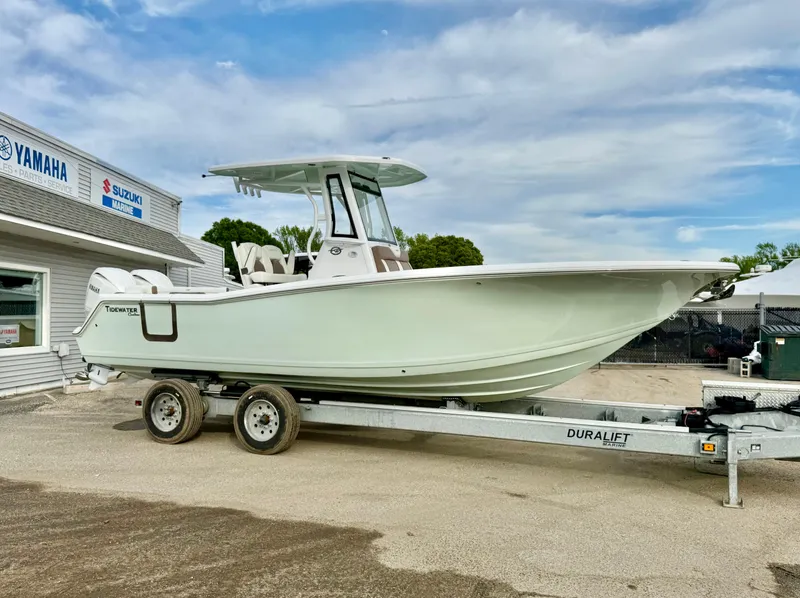 Slide: The Image of 2025 Tidewater 256 LXF boat on trailer outside dealership, clear sky background. - 11