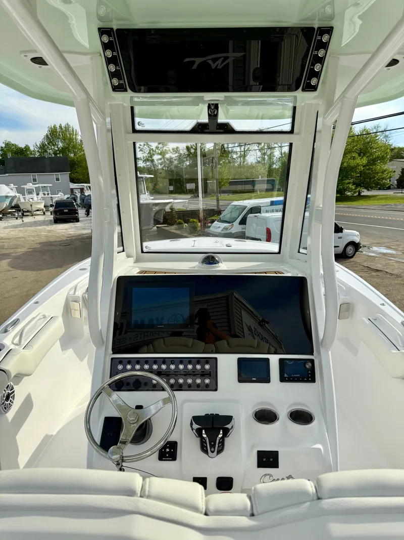 Slide: The Image of 2025 Tidewater 256 LXF boat dashboard with steering wheel and control panel. - 15