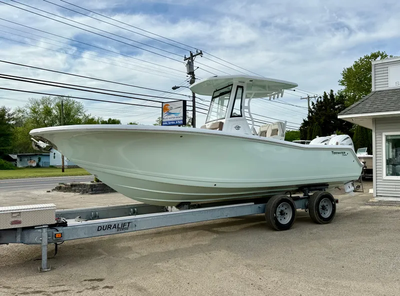 Slide: The Image of 2025 Tidewater 256 LXF boat on a Duraljet trailer, parked outdoors. - 2