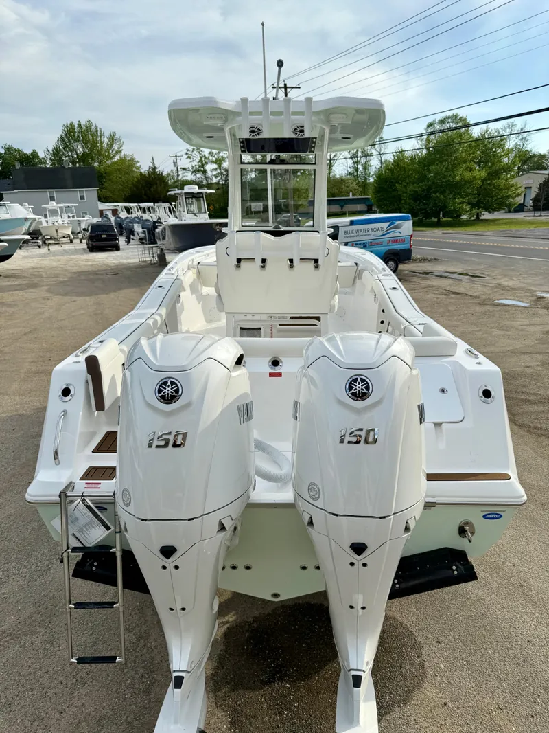Slide: The Image of 2025 Tidewater 256 LXF boat with dual 150 horsepower engines, docked outdoors. - 25