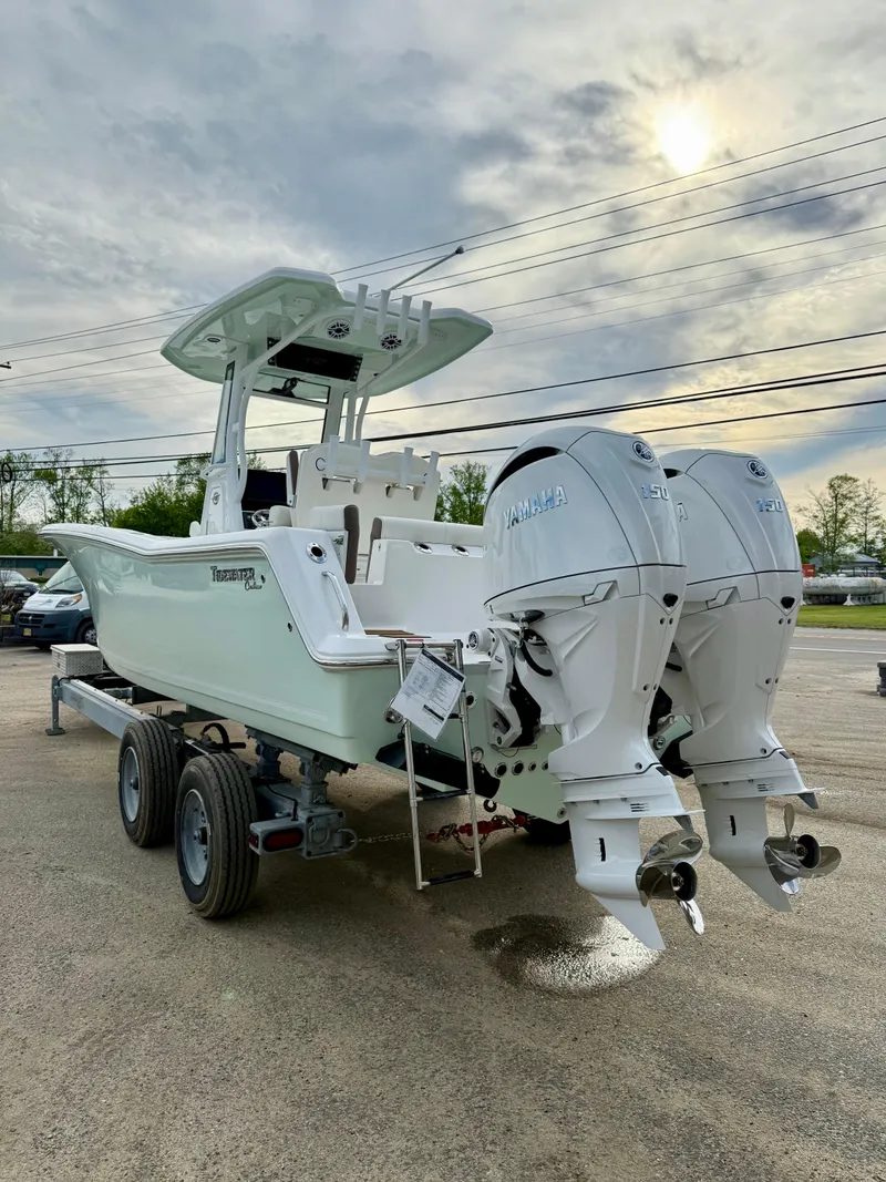 Slide: The Image of 2025 Tidewater 256 LXF boat with dual engines on a trailer, under a cloudy sky. - 3