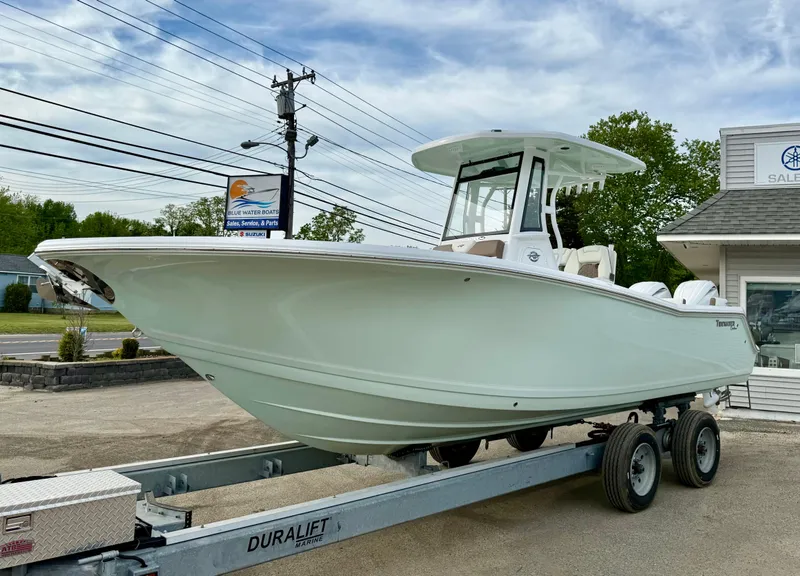 Slide: The Image of 2025 Tidewater 256 LXF boat on trailer, displayed outdoors near dealership. - 9