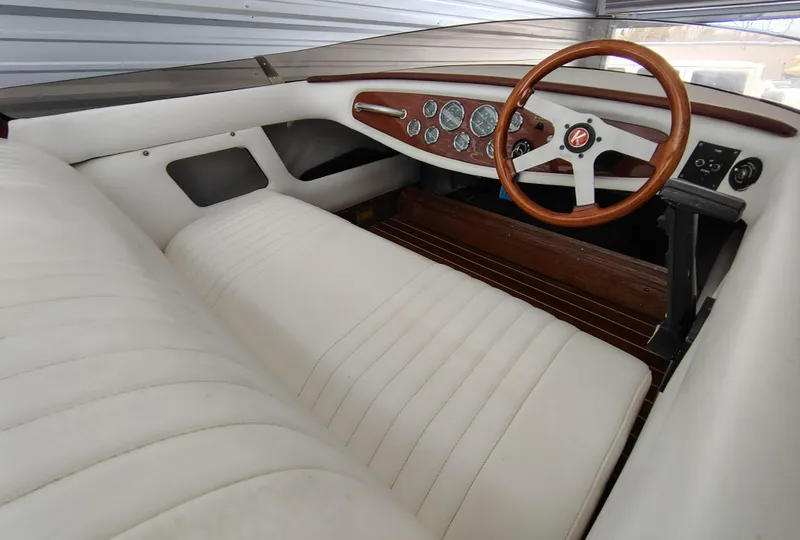 Slide: The Image of 1989 Kavalk Continental boat interior with white leather seats and wooden steering wheel. - 10