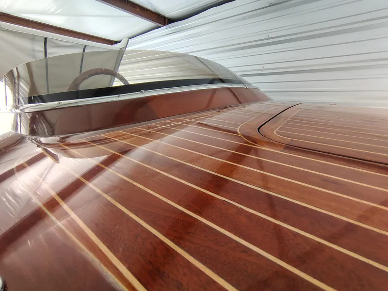 Slide: The Image of 1989 Kavalk Continental boat with polished wooden deck and sleek windshield in storage. - 7