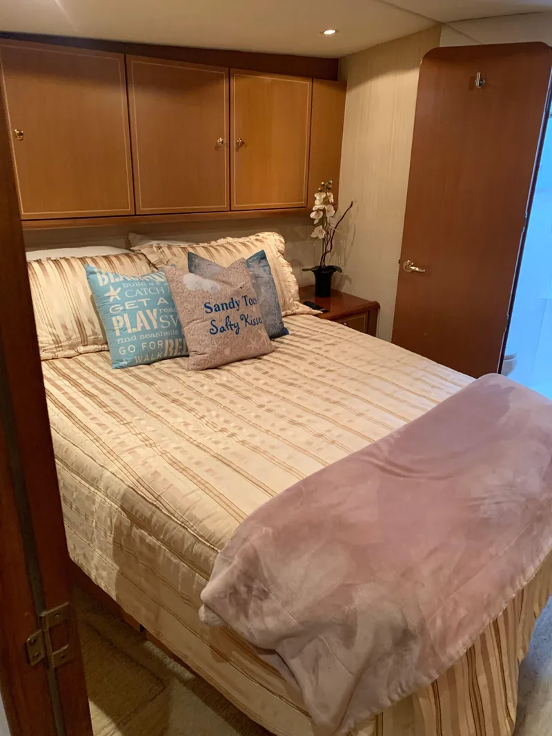 Slide: The Image of Cozy bedroom in 2004 Ocean Yachts 57 Odyssey with decorative pillows and wooden cabinets. - 26