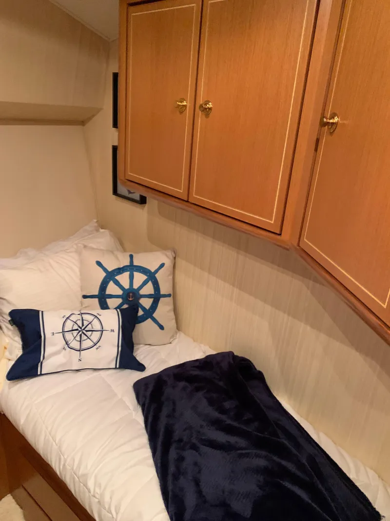 Slide: The Image of Cozy cabin bed with nautical-themed pillows in 2004 Ocean Yachts 57 Odyssey. - 48