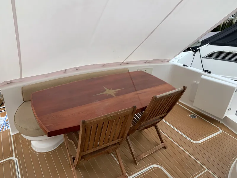 Slide: The Image of Luxury 2004 Ocean Yachts 57 Odyssey deck with elegant wooden dining table and chairs. - 5