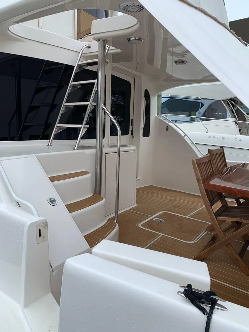 Slide: The Image of 2004 Ocean Yachts 57 Odyssey yacht deck with seating and stairs. - 4