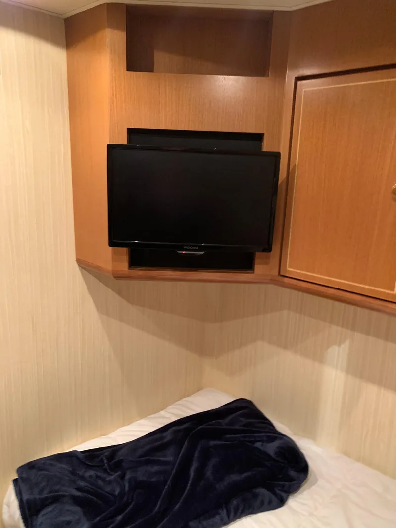 Slide: The Image of 2004 Ocean Yachts 57 Odyssey cabin with TV and cozy bedding. - 49