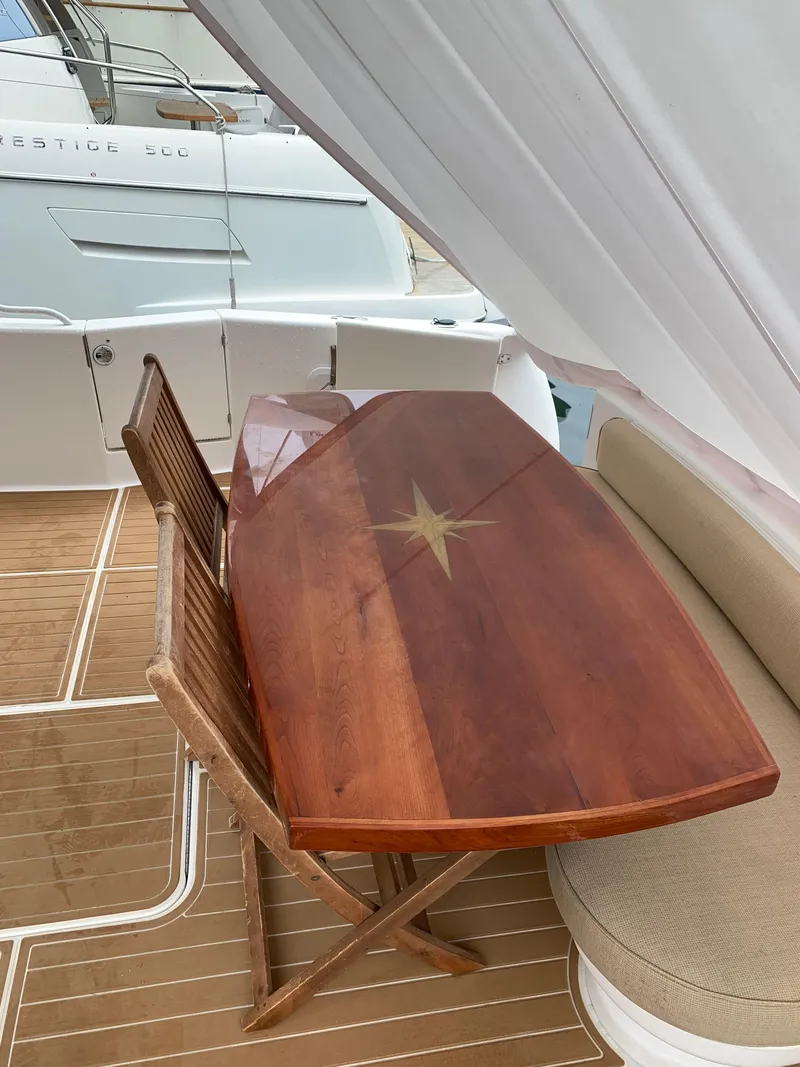 Slide: The Image of Luxurious 2004 Ocean Yachts 57 Odyssey with elegant wooden deck table and seating. - 6
