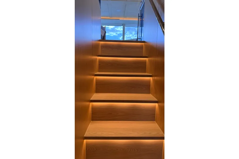 Slide: The Image of Illuminated wooden stairs inside a 2025 Granocean W72 yacht, leading to a bright upper deck. - 21