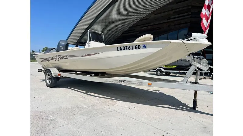 Slide: The Image of 2014 Express XP 18 CC boat on trailer, parked outdoors. - 2