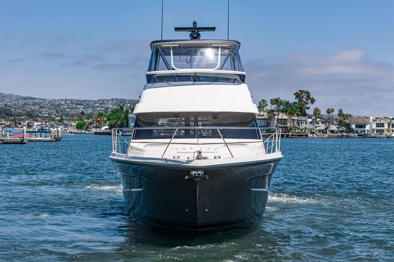 Slide: The Image of 2025 Riviera 46 Sport Motor Yacht cruising on a scenic waterway. - 11