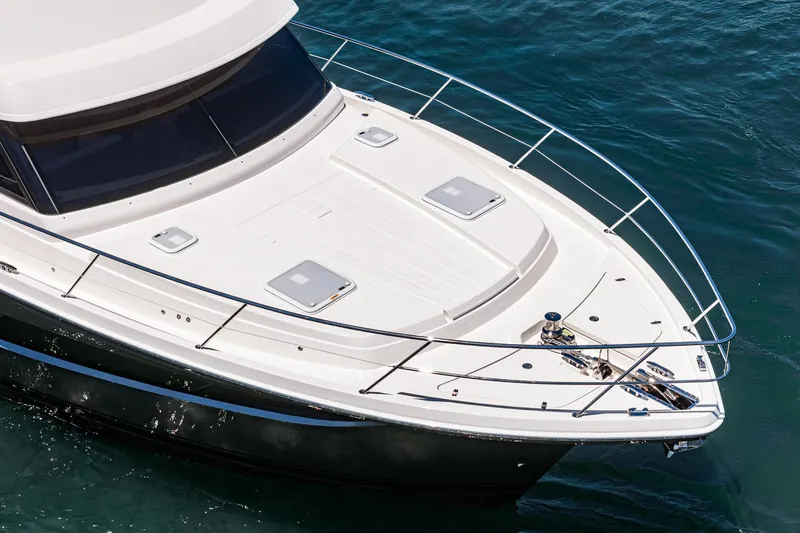 Slide: The Image of 2025 Riviera 46 Sport Motor Yacht on calm blue water. - 12