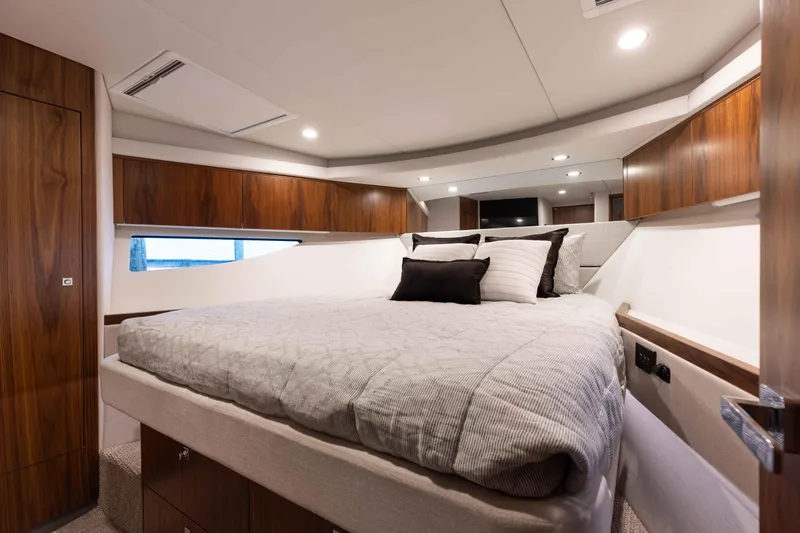 Slide: The Image of Luxurious bedroom in 2025 Riviera 46 Sport Motor Yacht with modern wood accents. - 16