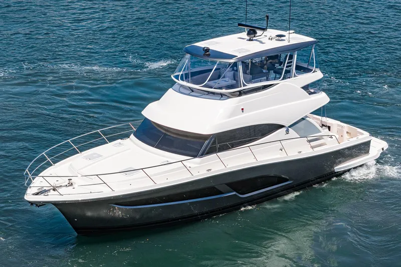 Slide: The Image of 2025 Riviera 46 Sport Motor Yacht cruising on open water. - 2