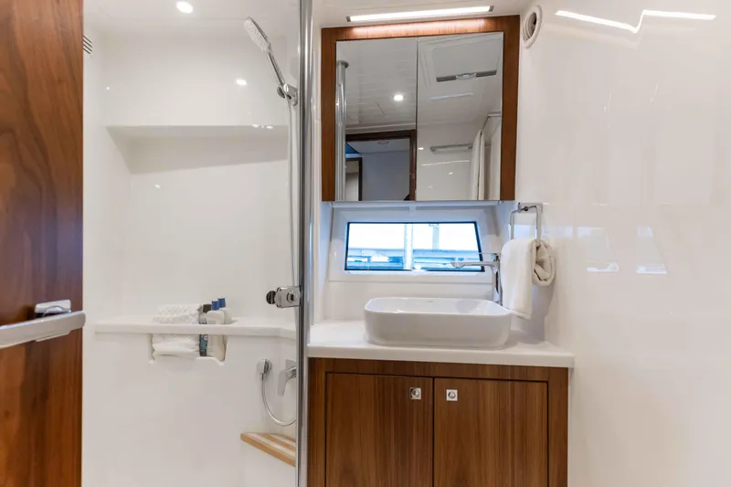 Slide: The Image of Luxurious bathroom in 2025 Riviera 46 Sport Motor Yacht with modern fixtures and wooden cabinetry. - 20