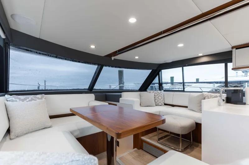 Slide: The Image of Luxurious interior of 2025 Riviera 46 Sport Motor Yacht with elegant seating and wooden table. - 32