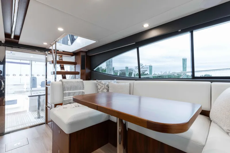 Slide: The Image of Interior of 2025 Riviera 46 Sport Motor Yacht with elegant seating and wooden table. - 34