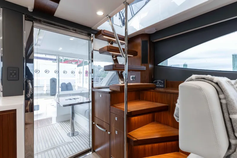 Slide: The Image of Interior of 2025 Riviera 46 Sport Motor Yacht with wooden stairs and modern design. - 38