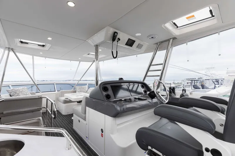 Slide: The Image of 2025 Riviera 46 Sport Motor Yacht interior with modern helm and seating. - 39