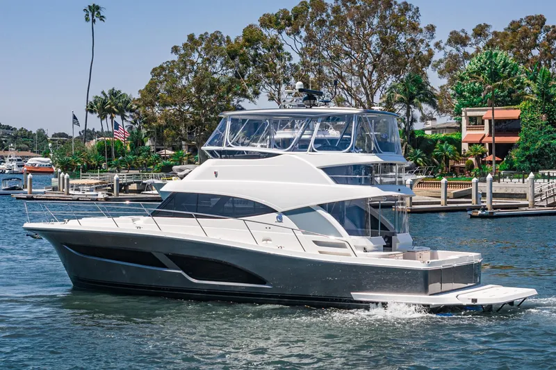 Slide: The Image of 2025 Riviera 46 Sport Motor Yacht cruising in a scenic marina setting. - 4