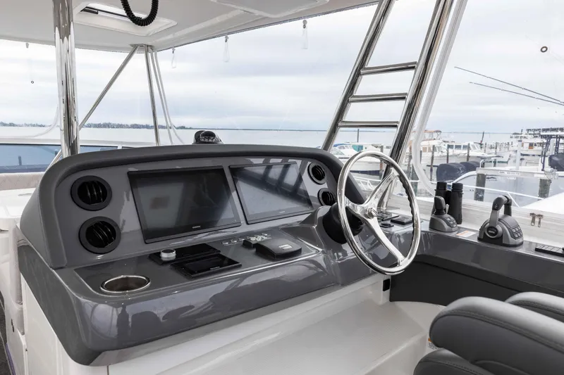 Slide: The Image of Helm of 2025 Riviera 46 Sport Motor Yacht with modern controls and ocean view. - 47