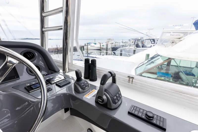 Slide: The Image of Helm of 2025 Riviera 46 Sports Motor Yacht with controls and binoculars. - 49