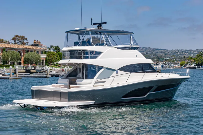 Slide: The Image of 2025 Riviera 46 Sport Motor Yacht cruising in a scenic marina setting. - 7