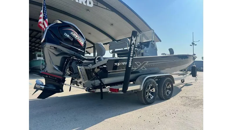 Slide: The Image of 2023 Express H22B boat with Yamaha engine on trailer, parked outside dealership. - 2