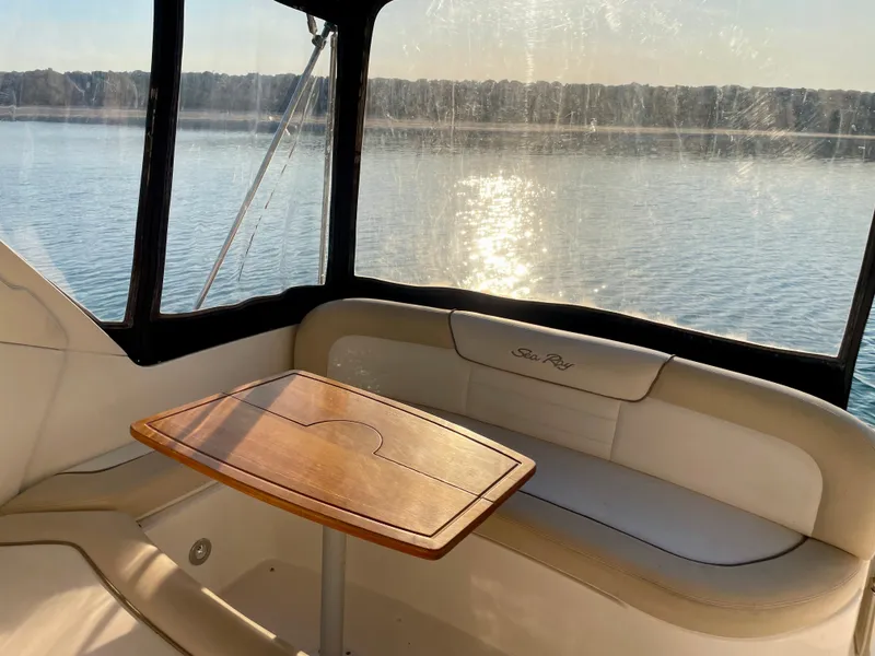 Slide: The Image of 2014 Sea Ray 330 Sundancer interior with table, overlooking serene water view. - 26