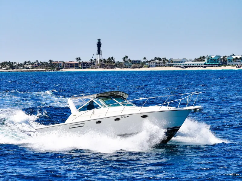 Slide: The Image of 1998 Tiara Yachts 3100 Open cruising on blue ocean near a lighthouse. - 0