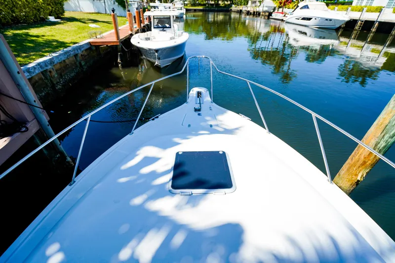 Slide: The Image of Bow view of 1998 Tiara Yachts 3100 Open docked in a serene marina. - 17