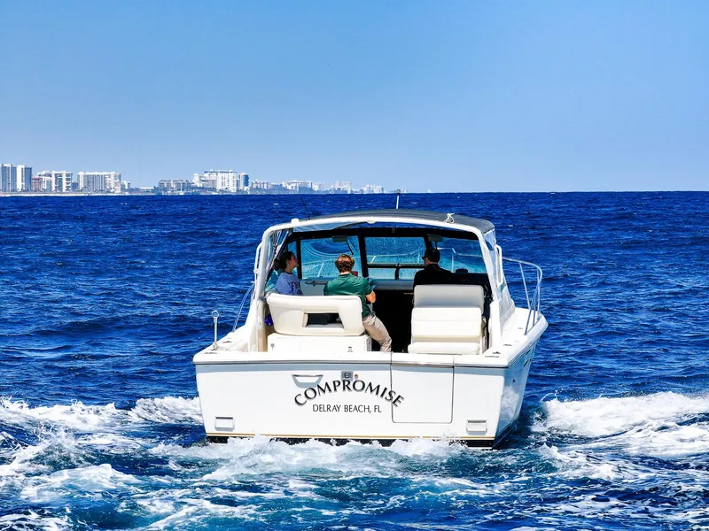 Slide: The Image of 1998 Tiara Yachts 3100 Open cruising on ocean near city skyline. - 5