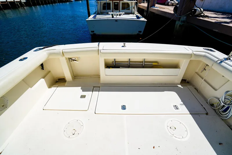 Slide: The Image of 1998 Tiara Yachts 3100 Open boat deck with storage compartments and docked view. - 7
