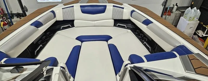 Slide: The Image of 2020 Malibu M240 boat interior with white and blue seating, spacious and luxurious design. - 12