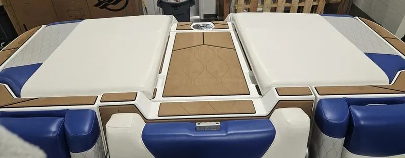 Slide: The Image of 2020 Malibu M240 boat interior with white and blue cushioned seating. - 13