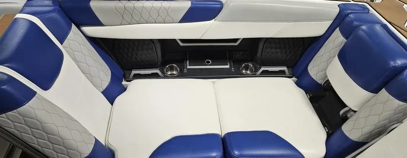 Slide: The Image of 2020 Malibu M240 boat interior with blue and white leather seating, featuring cup holders. - 14